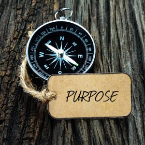 compass and a small card board written purpose