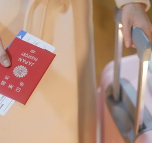 fashion dress girl with a suitcase holds japan passport