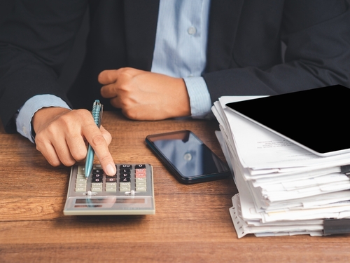 Tax day concept. Businessman uses a calculator to calculate the tax