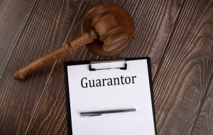 Guarantor Text On Paper With Gavel On The Wooden Background