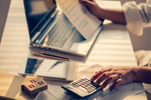 Hand,Of,Business,People,Calculating,Interest,,Taxes,And,Profits,To