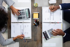 Two,Business,Colleagues,Calculating,Tax,In,Office